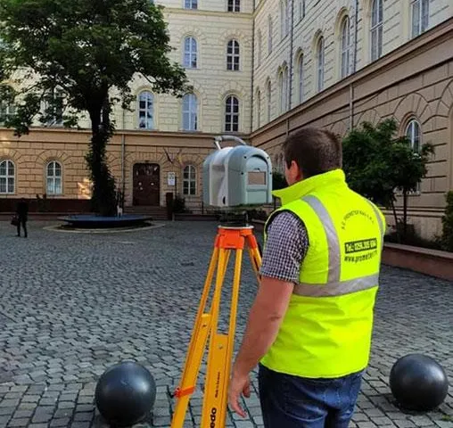 Specialist PROMETER M&G operând un scanner laser 3D în curtea unei clădiri istorice