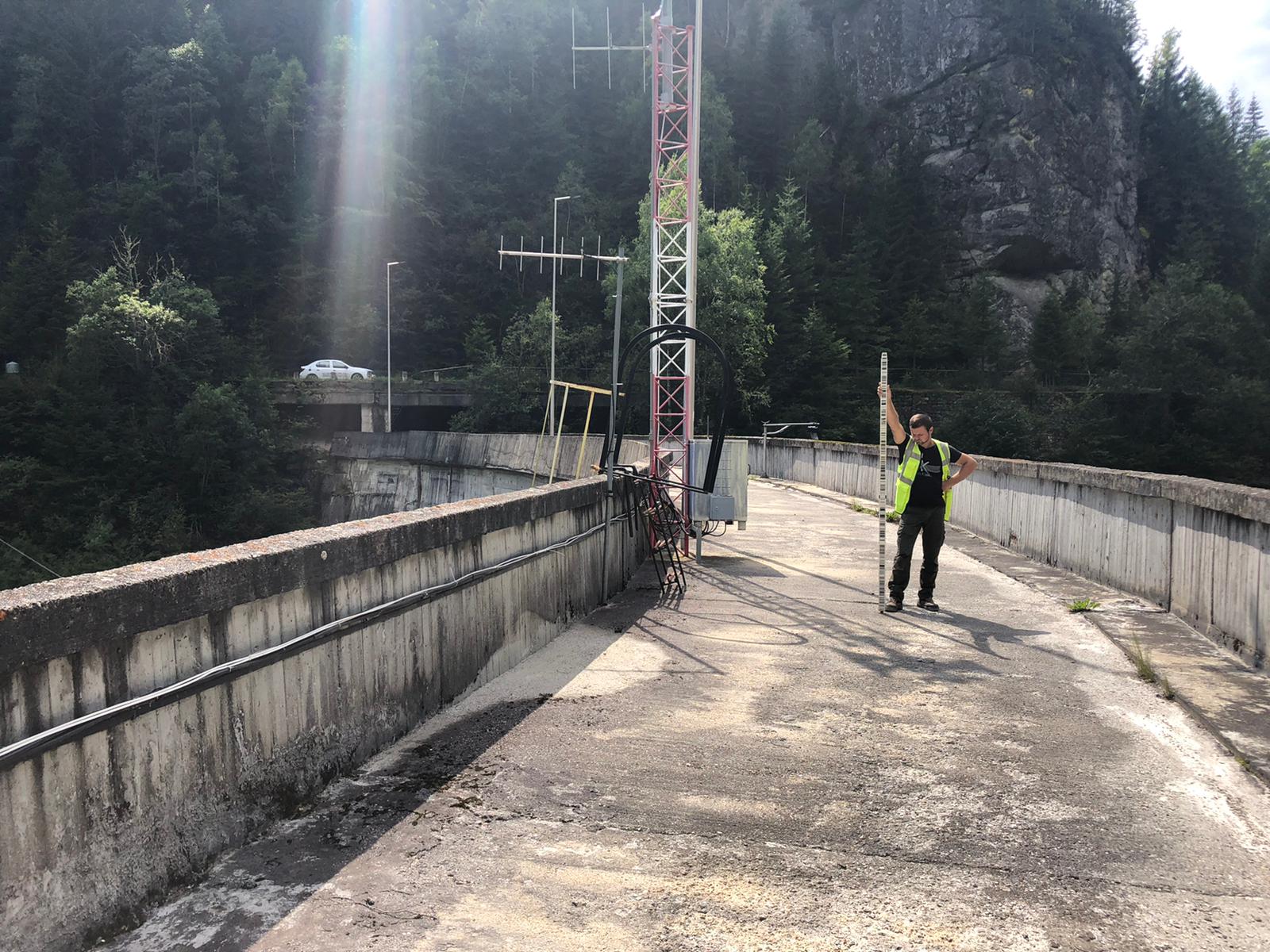 Coleg PROMETER M&G măsurând pe un baraj, în zonă montană
